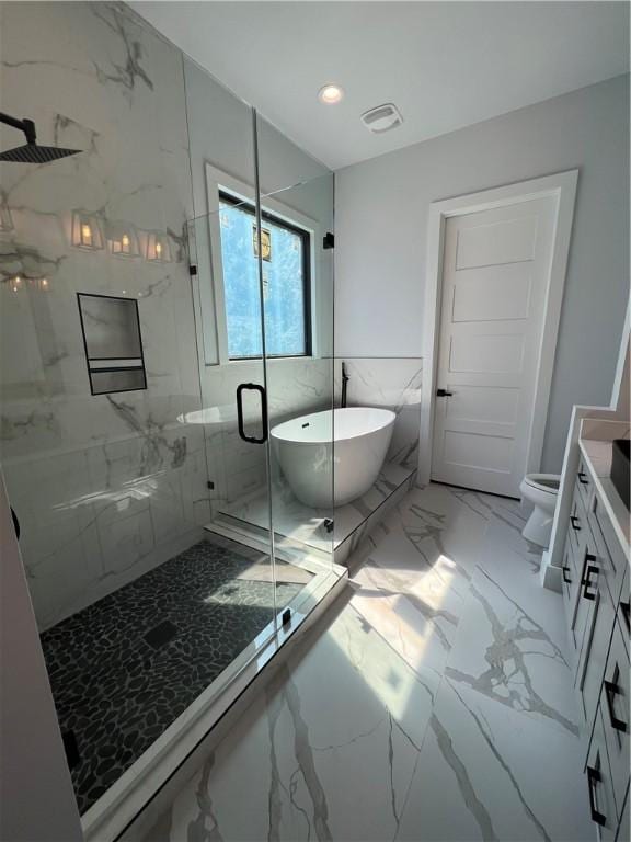 bathroom featuring a freestanding tub, vanity, toilet, marble finish floor, and a marble finish shower