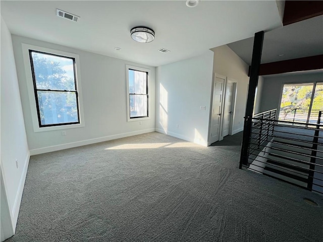 unfurnished room with baseboards, carpet floors, and visible vents