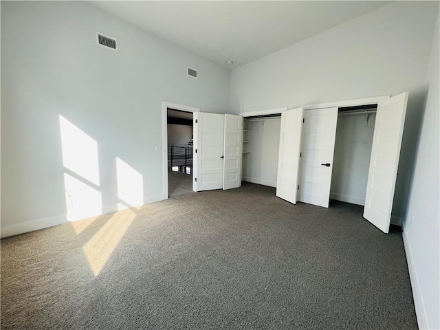 6308 Hudson Bend Rd, Austin, TX 78734 - unfurnished bedroom with multiple closets, dark carpet, baseboards, and a high ceiling