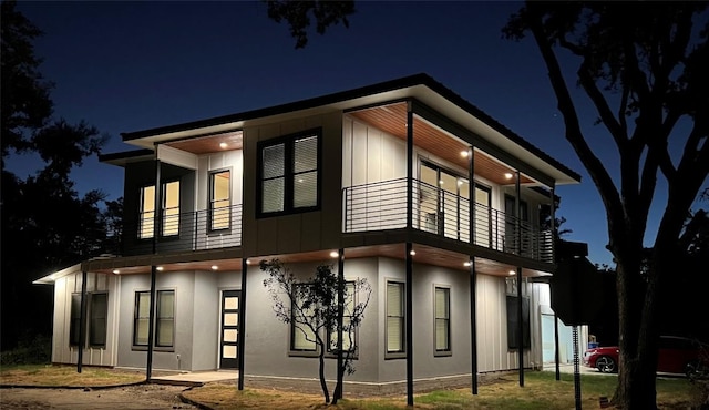 6308 Hudson Bend Rd, Austin, TX 78734 - property exterior at night featuring a balcony and stucco siding