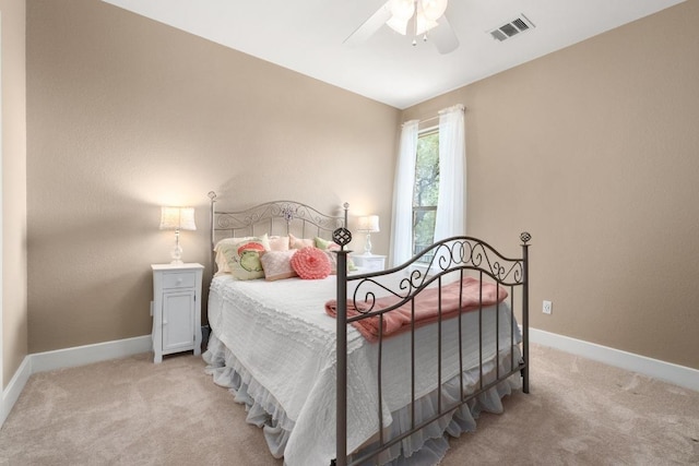 bedroom featuring baseboards, light carpet, a ceiling fan, and visible vents