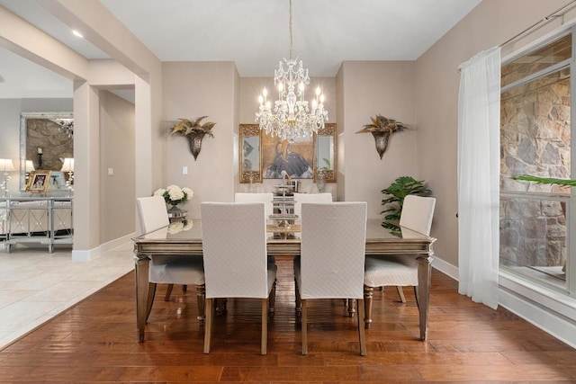dining area featuring baseboards, a chandelier, and wood finished floors