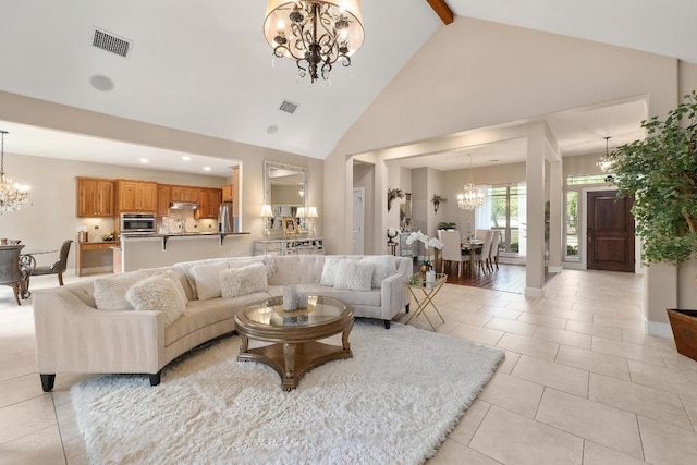 living area featuring visible vents, a notable chandelier, and high vaulted ceiling