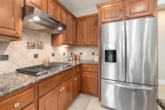 kitchen with stainless steel appliances, brown cabinets, and under cabinet range hood