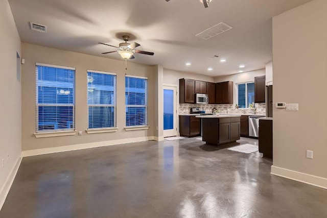 kitchen with baseboards, appliances with stainless steel finishes, concrete floors, and visible vents