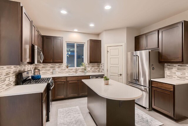 kitchen featuring a sink, decorative backsplash, appliances with stainless steel finishes, and light countertops