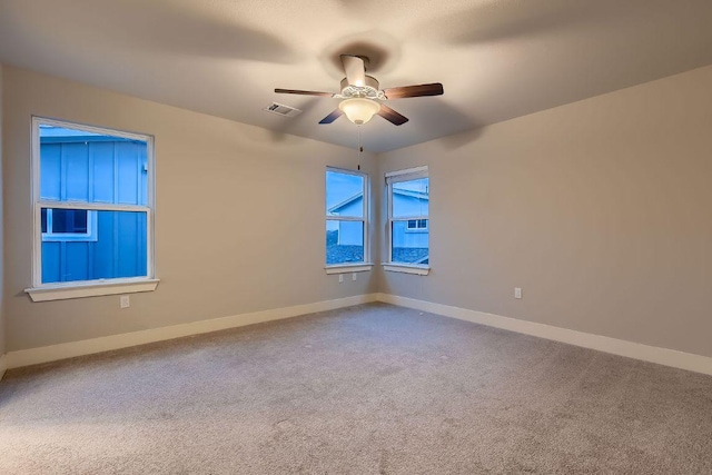 unfurnished room featuring carpet floors, ceiling fan, visible vents, and baseboards