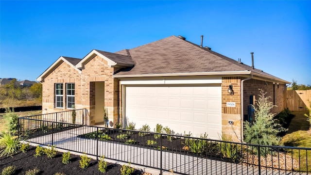 ranch-style home with brick siding, a shingled roof, a garage, and fence