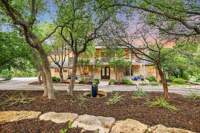 view of front of home with french doors, covered porch, and stone siding