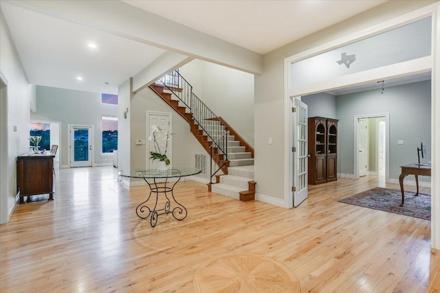 foyer entrance featuring recessed lighting, baseboards, wood finished floors, and stairway