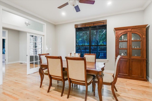 dining area featuring crown molding, ceiling fan, baseboards, and light wood-style floors