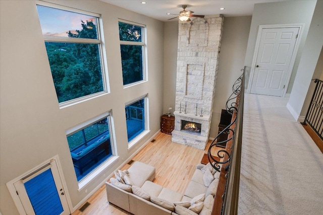 living room with a fireplace, a ceiling fan, recessed lighting, wood finished floors, and visible vents