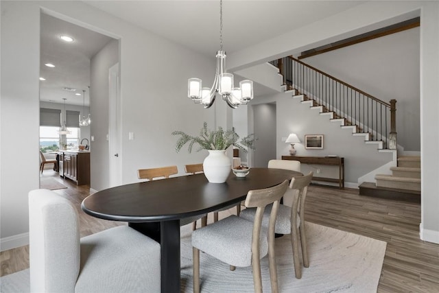 2033 Portobello Rd, Leander, TX 78641 - dining area featuring wood finished floors, stairway, recessed lighting, and a chandelier