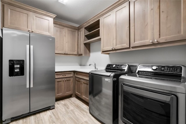 2033 Portobello Rd, Leander, TX 78641 - laundry area featuring cabinet space, light wood finished floors, and washing machine and dryer
