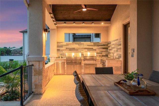 2033 Portobello Rd, Leander, TX 78641 - patio terrace at dusk featuring exterior kitchen, a ceiling fan, a balcony, and outdoor dining space