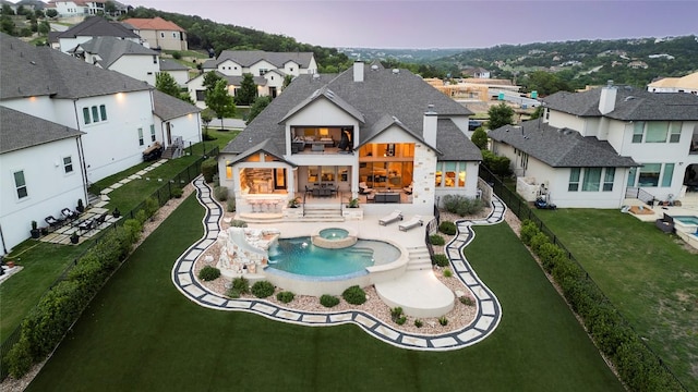 2033 Portobello Rd, Leander, TX 78641 - back of property with a balcony, a residential view, a pool with connected hot tub, a shingled roof, and a patio area