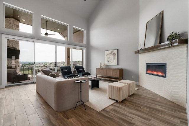 2033 Portobello Rd, Leander, TX 78641 - living area featuring high vaulted ceiling, a glass covered fireplace, a ceiling fan, and wood finished floors