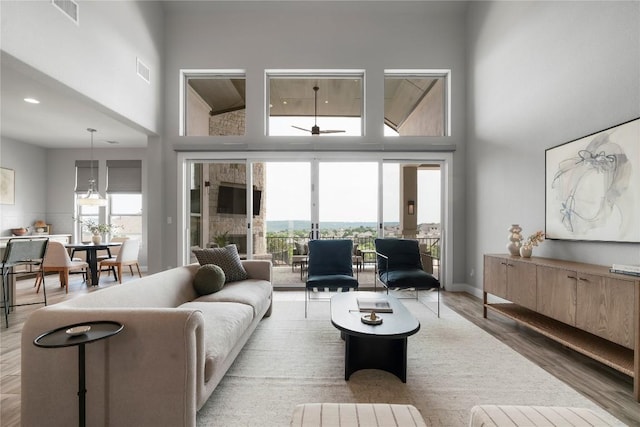 2033 Portobello Rd, Leander, TX 78641 - living area featuring a towering ceiling, wood finished floors, healthy amount of natural light, and a ceiling fan