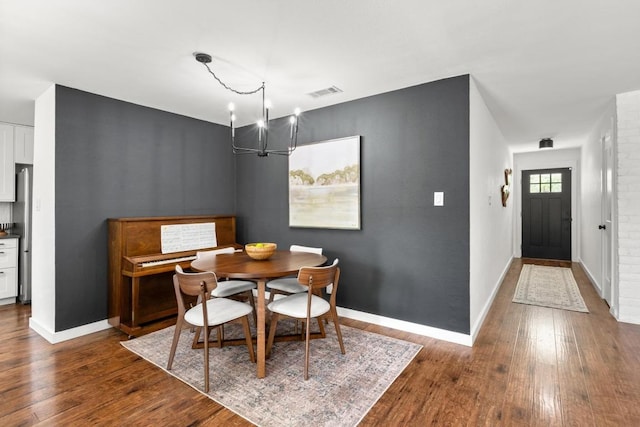 dining area with an inviting chandelier, baseboards, dark wood-style floors, and visible vents