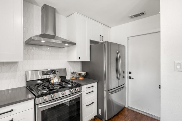 kitchen with visible vents, dark countertops, wall chimney range hood, backsplash, and stainless steel appliances
