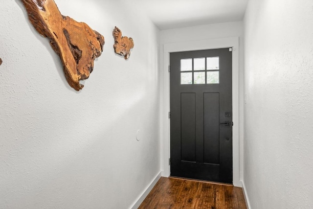 doorway to outside with baseboards and dark wood-style floors