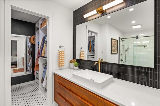ensuite bathroom with a shower stall, ensuite bathroom, tasteful backsplash, and vanity