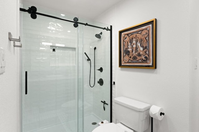 full bath featuring a stall shower and toilet