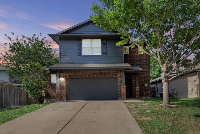traditional-style home with a lawn, a garage, brick siding, fence, and concrete driveway