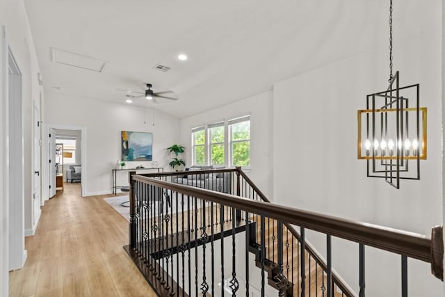hallway featuring light wood-style flooring, attic access, baseboards, an upstairs landing, and visible vents