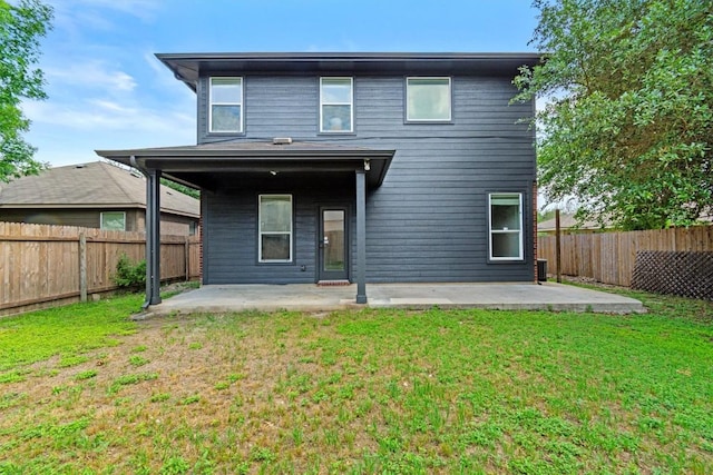 rear view of house featuring a lawn, a fenced backyard, and a patio area