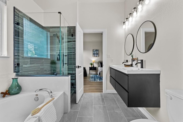 full bathroom with double vanity, toilet, baseboards, a bath, and a stall shower