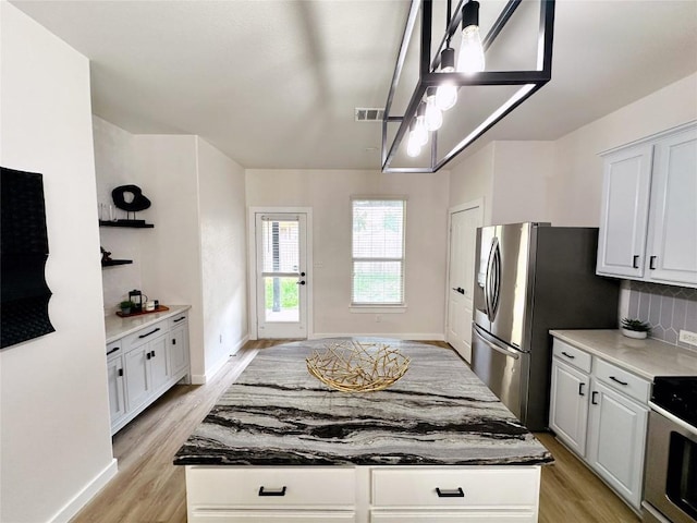 1728 Strobel Ln, Austin, TX 78748 - kitchen with light wood-type flooring, range, decorative backsplash, and white cabinetry