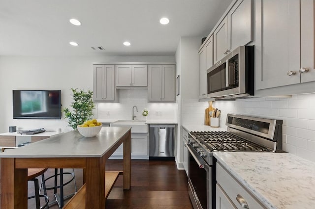 kitchen featuring a sink, gray cabinets, stainless steel appliances, dark wood-type flooring, and visible vents