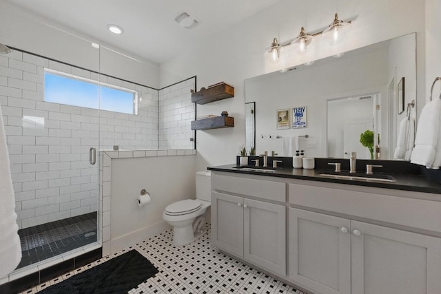 full bath with a sink, a stall shower, toilet, and double vanity