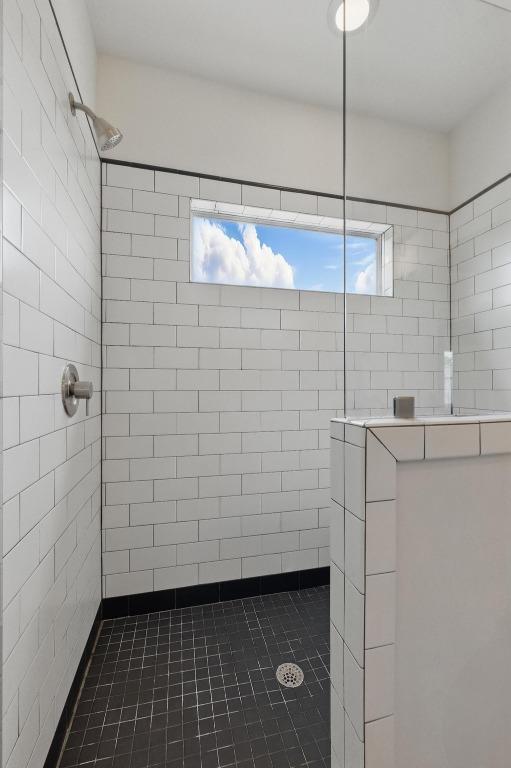 bathroom with plenty of natural light, tile patterned floors, and tiled shower