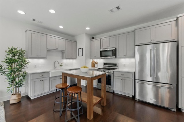 kitchen with stainless steel appliances, visible vents, and gray cabinetry