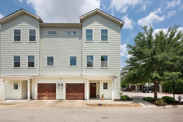 multi unit property featuring a garage and driveway
