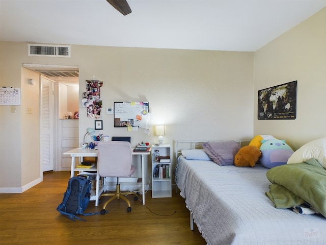bedroom with baseboards, wood finished floors, and visible vents