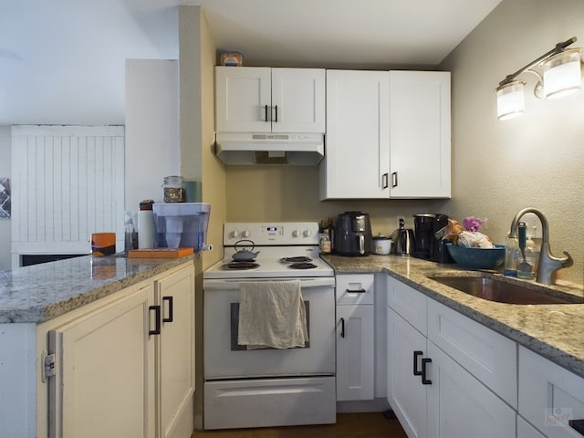 kitchen featuring a peninsula, under cabinet range hood, white cabinets, a sink, and white electric stove