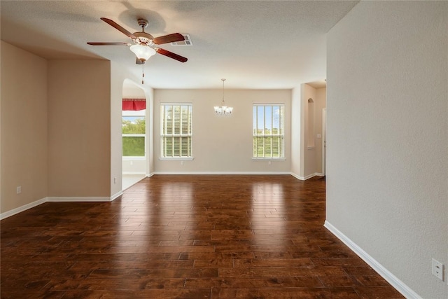 spare room with visible vents, baseboards, ceiling fan with notable chandelier, and dark wood-style floors