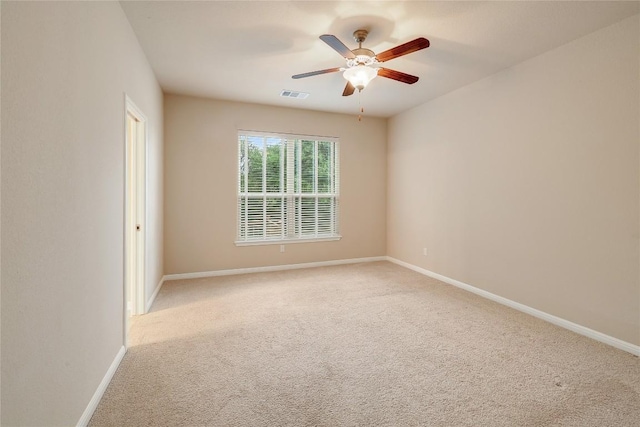 unfurnished room featuring baseboards, ceiling fan, light carpet, and visible vents