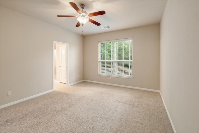 unfurnished room with visible vents, baseboards, ceiling fan, and light colored carpet