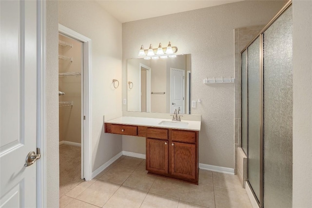 bathroom featuring tile patterned floors, a walk in closet, and a stall shower