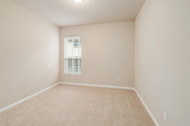 empty room with baseboards and light carpet