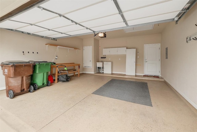 garage featuring a sink, a garage door opener, and electric panel