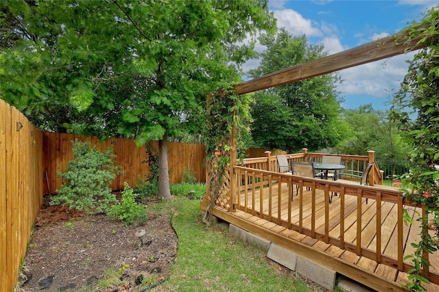 view of yard with outdoor dining area, a wooden deck, and a fenced backyard