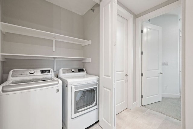 clothes washing area featuring laundry area and washer and clothes dryer