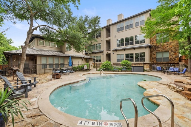 pool with a patio area and fence