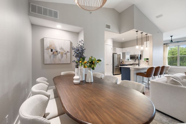 dining area featuring a ceiling fan, high vaulted ceiling, visible vents, and baseboards