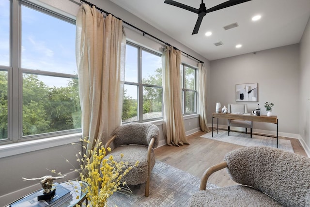 home office with visible vents, baseboards, ceiling fan, and light wood-style floors